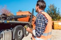 Worker on construction site unloading container for waste from truck Royalty Free Stock Photo
