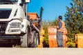 Worker on construction site unloading container for waste from truck Royalty Free Stock Photo