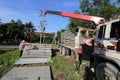 Worker controls of lifting crane in crane truck