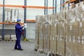 Worker counting stocks in warehouse Royalty Free Stock Photo