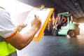 Worker Courier Holding Clipboard his Control Loading Package Boxes into Cargo Container. Supply Chain. Trucks Loading at Dock. Royalty Free Stock Photo