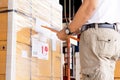 Worker courier holding clipboard writing on checklist for delivering shipment pallet goods