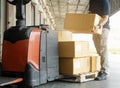 Worker courier lifting shipments boxes at the warehouse. Royalty Free Stock Photo