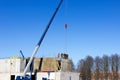 The worker and the crane operator unload the car with reinforced concrete walls for building a large wellness center with a