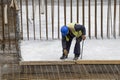 Worker with crowbar removing wooden formworks