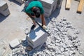 A worker cuts aerated concrete bricks with a saw