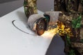 worker cuts a circle in metal with an angle grinder