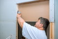 Worker cuts drywall with a using multi tool Royalty Free Stock Photo