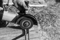 The worker cuts the metal with an angle grinder, the work is carried out on the street Royalty Free Stock Photo