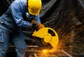 Worker cuts metal by electric circular saw. Fountain of grinding metal sparks. Metal working with personnel protective equipment Royalty Free Stock Photo