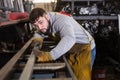 Worker cuts metal profile pipe on a band saw Royalty Free Stock Photo