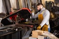 Worker cuts metal profile pipe on a band saw Royalty Free Stock Photo