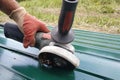 Worker cuts a metal sheet with an angle grinder outdoors in the village Royalty Free Stock Photo