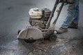 Worker cuts a piece of asphalt using a cutting machine pavement. Royalty Free Stock Photo