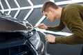 Worker cuts protection film on car hood Royalty Free Stock Photo