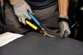 A worker cuts a sheet of roofing iron with metal scissors Royalty Free Stock Photo