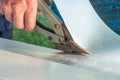 A worker cuts a sheet of tin with metal shears Royalty Free Stock Photo