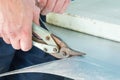 A worker cuts a sheet of tin with metal shears Royalty Free Stock Photo