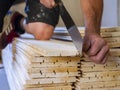 worker cuts wooden slats