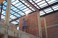Worker cutting the brick wall with steel roof structure and blue sky in background Royalty Free Stock Photo