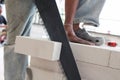 Worker cutting bricks with crosscut saw. Royalty Free Stock Photo