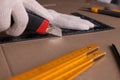 Worker cutting cardboard with utility knife and ruler, closeup Royalty Free Stock Photo