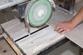 A worker is cutting a ceramic tile on a special electric wet water cutter saw machine. Maintenance repair in the flat. Renovation Royalty Free Stock Photo