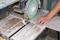 A worker is cutting a ceramic tile on a special electric wet water cutter saw machine. Maintenance repair in the flat. Renovation Royalty Free Stock Photo