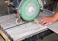 A worker is cutting a ceramic tile on a special electric wet water cutter saw machine. Maintenance repair in the flat. Renovation Royalty Free Stock Photo