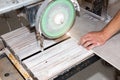 A worker is cutting a ceramic tile on a special electric wet water cutter saw machine. Maintenance repair in the flat. Renovation Royalty Free Stock Photo