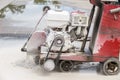 Worker cutting concrete road with diamond saw blade machine Royalty Free Stock Photo