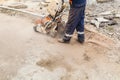 A worker cutting concrete road with diamond saw blade machine Royalty Free Stock Photo