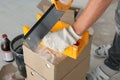 Worker cutting decorative bricks with saw indoors, closeup