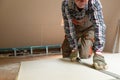 Worker cutting drywall plasterboard with construction knife. Attic renovation Royalty Free Stock Photo