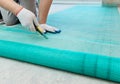 A worker is cutting a fiberglass mesh