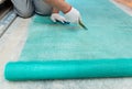 A worker is cutting a fiberglass mesh