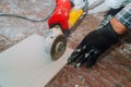 Worker cutting flooring tile with an diamond electric saw blade a construction site Royalty Free Stock Photo