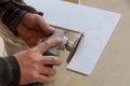 Worker cutting flooring tile with an diamond electric saw blade a construction site Royalty Free Stock Photo