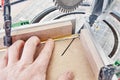 Worker cutting golden moulding on miter saw closeup