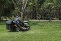 Worker cutting grass lawn mower in green field in garden Royalty Free Stock Photo