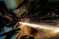 Worker cutting metal with grinder. Sparks while grinding iron