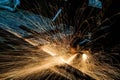 Worker cutting metal with grinder. Sparks while grinding iron