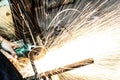 Worker cutting metal with grinder. Sparks while grinding iron