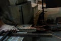 Worker cutting metal with grinder. Sparks while grinding iron