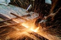 Worker cutting metal with grinder. Sparks while grinding iron