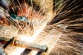 Worker cutting metal with grinder. Sparks while grinding iron