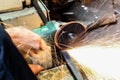 Worker cutting metal with grinder. Sparks while grinding iron