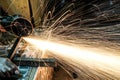 Worker cutting metal with grinder. Sparks while grinding iron