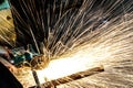 Worker cutting metal with grinder. Sparks while grinding iron