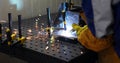 Worker cutting metalsheet by acetylene torch with bright sparks